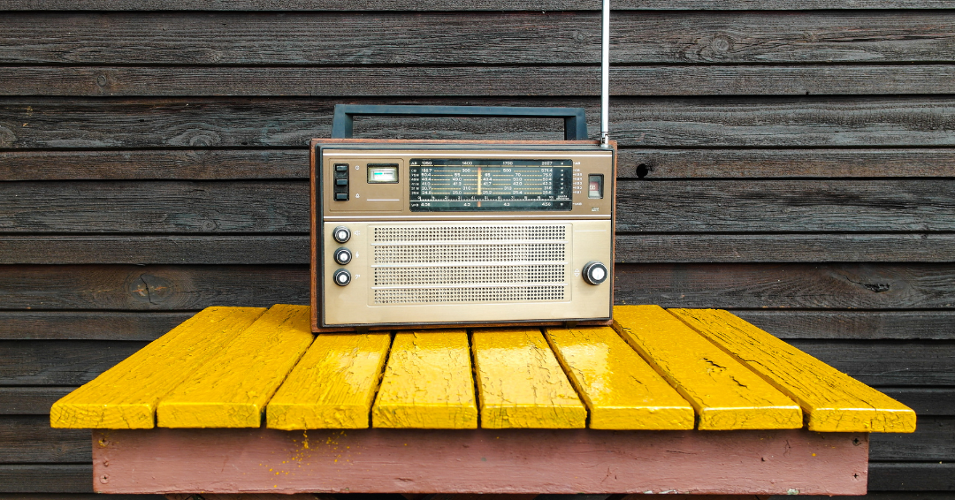 imagen de una radio antigua sobre mesa de madera de color amarillo